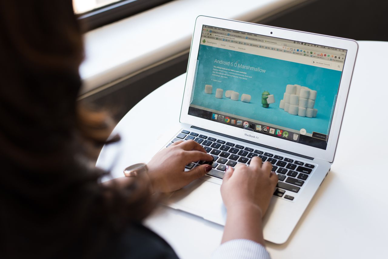 team-02 Businesswoman working on laptop with Android 6.0 Marshmallow webpage open.
